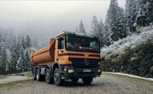 Camion Maurice BLANC garé en montagne au milieu des sapins enneigés